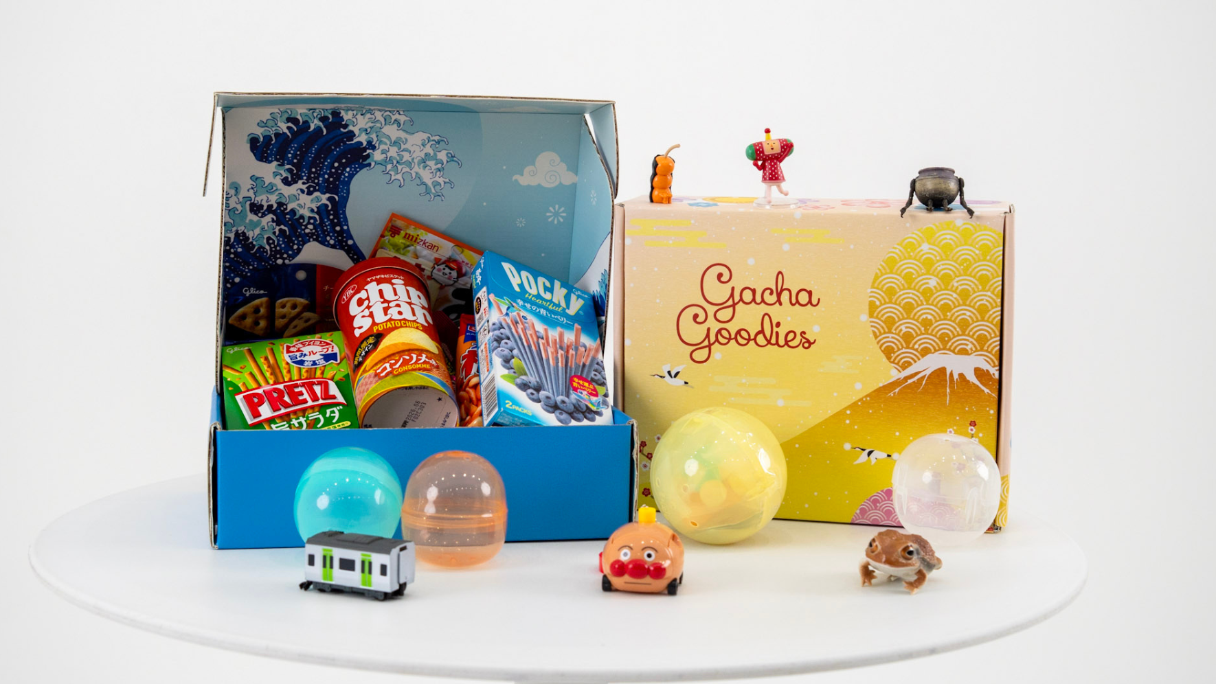 Gacha Goodies box with small toys and ornaments on a white surface